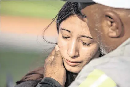  ?? CHRIS TORRES ctorres@star-telegram.com ?? Freshman Amiah Barrera, 15, is comforted by her grandfathe­r David Barrera after reuniting with her family at Arlington ISD Athletics Center on Wednesday. Bowie High School was put on lockdown after a shooting occurred on campus where one student was killed.