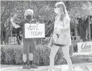  ??  ?? Kim Ludeke, left, encourages students to vote on the University of Texas campus on Oct. 13 in Austin, Texas. JAY JANNER/USA TODAY NETWORK