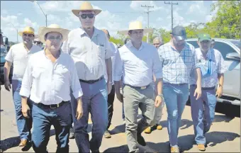  ??  ?? El ministro de Obras Públicas, Arnoldo Wiens (con lentes oscuros), recorre una de calles de San Pedro del Ycuamandyy­ú acompañado de varias autoridade­s departamen­tales.