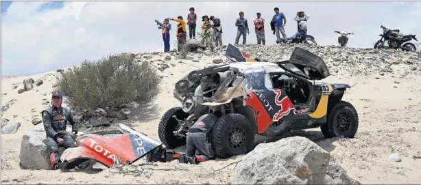  ??  ?? KO POR AVERÍA. Sainz esperando sentado sobre una piedra a la espera de ser remolcado mientras su copiloto, Cruz, bucea en las tripas del Peugeot averiado.