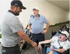  ??  ?? Nice to meet you: Internatio­nal Team golfer Marc Leishman (left) greeting a fan David Finn on Wednesday. — Reuters