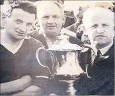  ??  ?? A joyful moment for Dave Hogan, the Kilworth captain, as he is presented with the championsh­ip trophy by Derry Gowen, chairman of the North Cork GAA Board, after Sunday’s hurling final at Buttevant. Pictured in the background is Mick Greehy.