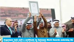  ??  ?? Organizers hold aloft a certificat­e by Guinness World Records endorsing the record. — Photo by Yasser Al-Zayyat (See Page 2)