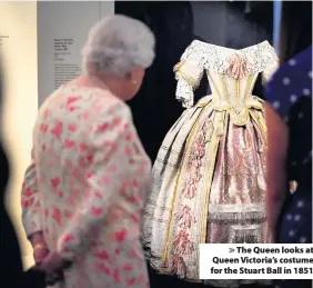  ??  ?? The Queen looks at Queen Victoria’s costume for the Stuart Ball in 1851