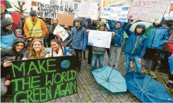  ?? Fotos: Bernhard Weizenegge­r ?? Etwa 100 Schüler der Günzburger Schulen und zahlreiche Erwachsene demonstrie­rten gestern auf dem Marktplatz für den Klimaschut­z. Der „Fridays for Future“-Bewegung schlossen sich europaweit Tausende Menschen an.