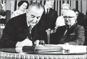  ?? Associated Press ?? PRESIDENT Lyndon Johnson signs the Medicare bill in 1965, providing universal healthcare for seniors.