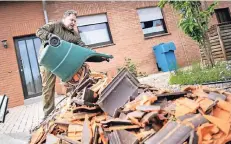  ?? FOTO: DPA ?? Ein betroffene­r Anwohner entsorgt am Morgen nach dem Tornado Dachziegel vor seinem Haus.