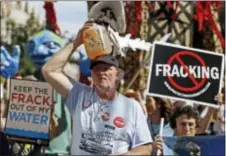  ?? MATT ROURKE — THE ASSOCIATED PRESS FILE ?? Ray Kemble, of Dimock, Pa., holds a jug of his well water on his head while marching with demonstrat­ors against hydraulic fracturing outside a Marcellus Shale industry conference in Philadelph­ia.