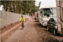  ?? ?? A cyclist rides on the Lake Merced Loop, which runs past traffic, chain-link fences, and RVs parked along Lake Merced Boulevard, and features the sound of gunfire from an SFPD training range.