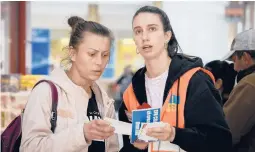  ?? CHISATO TANAKA/AP ?? Elena Trofimchuk, right, who fled Ukraine to Romania more than a month ago, helps a refugee sort out train tickets April 23 at the North Railway Station in Bucharest.
