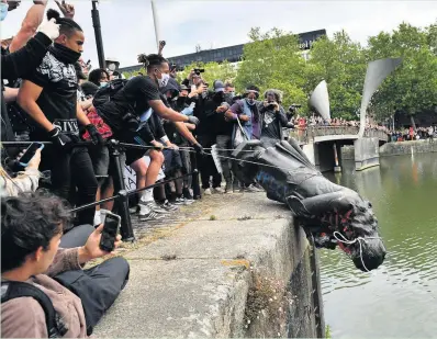  ??  ?? Protesters throwing the statue of Edward Colston into Bristol harbour last June
Ben Birchall/PA Wire