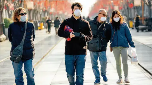  ?? by Xu Xun/china Pictorial ?? January 29, 2020: Foreign tourists walk along the Qianmen pedestrian street in Beijing.