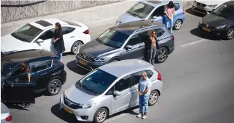  ?? (Avshalom Sassoni/Flash90) ?? MOTORISTS STAND at attention, in Tel Aviv, as sirens sound across Israel to mark Holocaust Remembranc­e Day, last Monday.