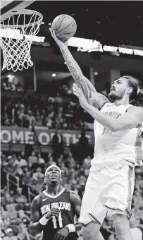  ?? [PHOTO BY NATE BILLINGS, THE OKLAHOMAN] ?? Oklahoma City’s Steven Adams goes up for a basket in front of New Orleans’ Jrue Holiday on Friday night in a preseason game at Chesapeake Energy Arena.