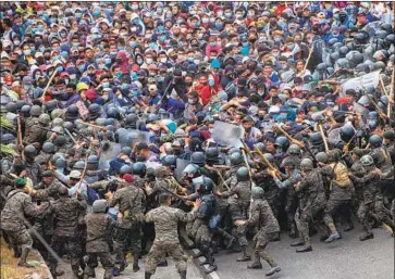  ?? Sandra Sebastian Associated Press ?? HONDURAN migrants clash with soldiers on Jan. 17 in Vado Hondo, Guatemala. The Biden administra­tion has not indicated that it will instruct other countries to ease their crackdowns on U.S.-bound migrants.