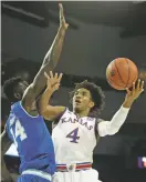  ?? ASSOCIATED PRESS FILE PHOTO ?? Kansas guard Devonte’ Graham, right, shoots while covered by Seton Hall forward Ismael Sanogo during a secondroun­d game of the NCAA Tournament on Saturday in Wichita, Kan. Kansas takes on Clemson in a regional semifinal Friday.