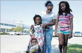  ?? Brian Melley ?? The Associated Press Tori Texada, 25, and her children Chloe, 7, right, Maddison, 6, and Paisley, 1, outside a shelter in Houston. The single mother of five is concerned about getting her kids back to her neighborho­od so they won’t miss any days of...