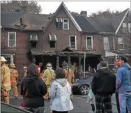  ?? PETE BANNAN – DIGITAL FIRST MEDIA ?? Residents and neighbors watch as Coatesvill­e firefighte­rs work at a house fire in the 700 block of East Chestnut Street on Monday afternoon.