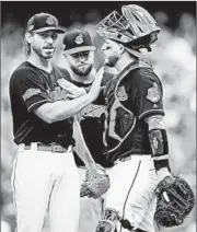  ?? MADDIE MEYER/GETTY ?? Indians catcher Roberto Perez gives Josh Tomlin a pat during a pitching change in the sixth inning Saturday.