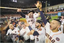  ?? David J. Phillip / Associated Press ?? The Astros’ Jose Altuve (27) is lifted by teammates after their Game 7 win over the Yankees. Altuve homered in the victory.