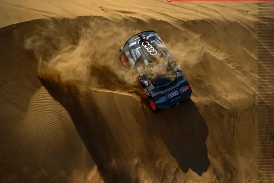  ?? ?? 2 1: Size does matter: the 1984 Quattro is dwarfed by the 2022 e-tron.’
2: The Audi e-tron scrabbles down a giant dune on the Dakar.