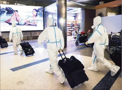  ?? Mario Tama / Getty Images ?? Air China flight crew members wear protective suits as they arrive in the internatio­nal terminal at Los Angeles Internatio­nal Airport on Dec. 3. As delays and pandemic-related holiday week flight cancellati­ons pile up across the country, U.S. Sen. Richard Blumenthal is turning up the heat on the airline industry to give full refunds for flights that don’t take off.
