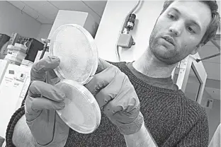  ?? AP Photo/Mary Altaffer ?? n Assistant research technician Henri Berger talks about live yeast cultures April 25 at a New York University lab in the Alexandria Center for Life Sciences in New York. Researcher­s at the lab are attempting to create custom-built DNA.