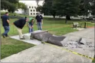  ?? JILL ZEMAN BLEED/THE ASSOCIATED PRESS ?? Personnel from the Secretary of State’s office inspect the damage to the new Ten Commandmen­ts monument outside the state Capitol in Little Rock, Ark., Wednesday morning.