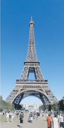  ?? KEVIN BISSETT/ THE CANADIAN PRESS ?? Tourists gather near the base of the Eiffel Tower in Paris. Organized tours give you the benefit of an experience­d tour director who has an in-depth knowledge of the city or country.