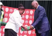  ?? ?? President Masisi receiving a token of appreciati­on from the CEO of NACLPMWU, Elsinah Botsalano