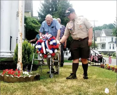  ?? CELIA SEUPEL — THE ASSOCIATED PRESS ?? World War II veteran Edwin Ford, left, and Boy Scout Russell Diers lay a wreath by the flagpole Saturday during the Kingston American Legion Post No. 150 centennial celebratio­n.