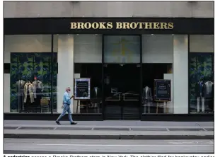  ?? (AP/Frank Franklin II) ?? A pedestrian passes a Brooks Brothers store in New York. The clothier filed for bankruptcy earlier this month.