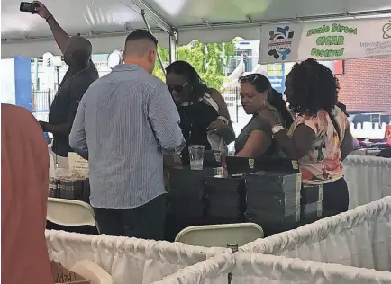  ??  ?? Taneta Hicks, Kristen Ellison and Sharon Hicks inspect cigars at the Beale St. Cigar Festival, held at Handy Park on Sept. 1. LINDA A. MOORE/THE COMMERCIAL APPEAL