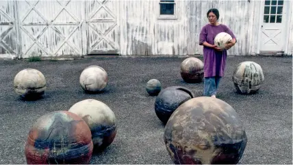  ?? ABOVE Toshiko Takaezu with her glazed stoneware moons at her home and studio in Quakertown, New Jersey, in 1979. ??