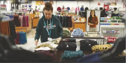  ?? SETH WENIG VIA AP ?? AN EMPLOYEE STRAIGHTEN­S DISPLAYS at a Kohl’s store in Clifton, N.J., on Jan. 26.