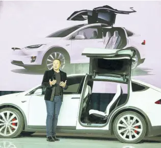  ??  ?? Tesla CEO Elon Musk speaks next to a Tesla vehicle. Musk has said his company will soon start accepting payment in bitcoin.