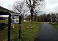  ?? DAN SOKIL - MEDIANEWS GROUP ?? A family walks down the trail running through Upper Gwynedd’s Parkside Place complex on Tuesday afternoon, March 17, past a taped-off pavilion and a message board featuring fliers for nowpostpon­ed events.