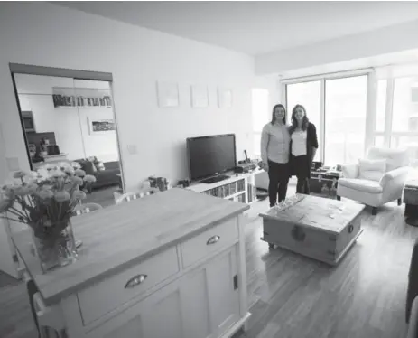  ?? MELISSA RENWICK/TORONTO STAR ?? An open-concept plan and floor-to-ceiling sliding glass doors help create a sense of space in the small condo of Paula Rayson, left, and Jenn Mason.