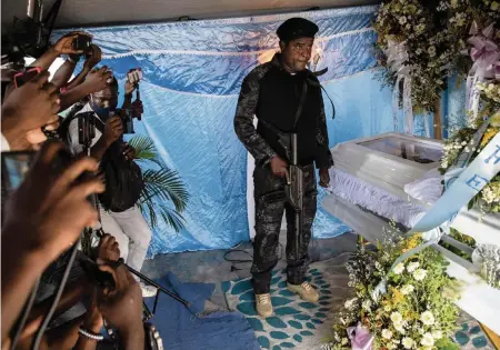  ?? RODRIGO ABD AP ?? Jimmy ‘Barbecue’ Chérizier, a former policeman who leads a gang, stands next to the coffin of one of his lieutenant­s in Port-au-Prince on Sept. 30. Chérizier said his lifting of a fuel blockade is only temporary to allow for the resignatio­n of interim Haiti Prime Minister Ariel Henry.