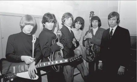  ??  ?? Rolling Stones guitarist Brian Jones, left, guitarist Keith Richards, vocalist Mick Jagger, bassist Bill Wyman and drummer Charlie Watts are seen with an unidentifi­ed woman as they prepared to rock the Vancouver Agrodome in 1965. A new album features...