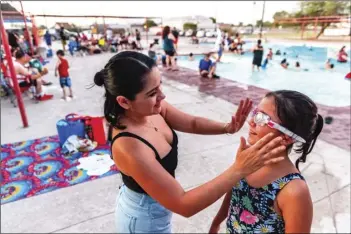  ?? PHOTO VINCENT OSUNA ?? Luz Genel (left) adjusts a pair of goggles for her daughter Ana Leia Gonzalez, 10, during Autism Support of Imperial County’s summer pool party on Saturday at the Imperial City Pool in Imperial.
