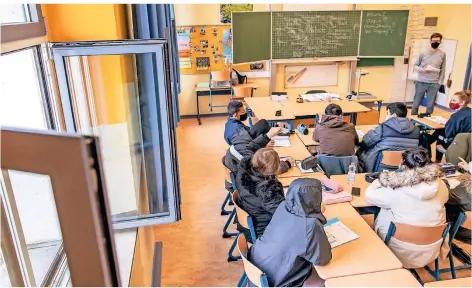  ?? FOTO: CHRISTOPH REICHWEIN ?? Schüler an der Gesamtschu­le Globus am Dellplatz in Duisburg sitzen in ihren dicken Winterjack­en bei offenem Fenster im Klassenrau­m.