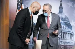  ?? ALEX WONG/GETTY ?? Sen. Cory Booker, left, and Senate Minority Leader Chuck Schumer have a discussion Tuesday at the Capitol. Democrats and Republican­s have offered separate policing plans.