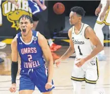  ??  ?? UMass Lowell’s Kalil Thomas celebrates after draining a 3-pointer in front of UMBC’s LJ Owens to tie the score during the second half of Saturday’s game.