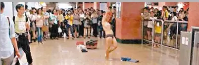  ??  ?? 菲籍女子在旺角站大堂­上大跳脫衣舞，引來大批乘客圍觀。（圖：東方日報提供）