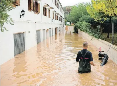  ?? DOMENECH CASTELLÓ / EFE ?? Un bombero achicaba ayer agua de bajos y garajes de casas cercanas a la playa del Carregador, en Alcossebre