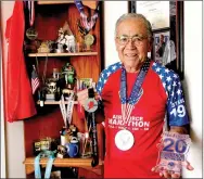  ?? LYNN KUTTER ENTERPRISE-LEADER ?? Koei Nakanishi, 81, of Farmington, displays his third-place trophy and medal from the 20th Air Force Marathon and his second-place medal from the Chili Pepper Cross Country Race in Fayettevil­le. Nakanishi has been running for about 30 years.