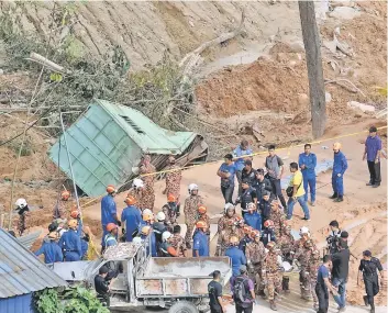  ??  ?? Bomba rescuers bringing out the seventh body from the landslide site. — Bernama photo