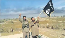  ?? AP FILE ?? An Islamic State militant waves the outfit’s flag in Fallujah, Iraq, west of Baghdad.