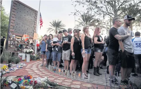  ?? EPA-EFE ?? People gather to dedicate a healing garden on the first anniversar­y of the shooting that killed 58 people and wounded hundreds in Las Vegas, Nevada.